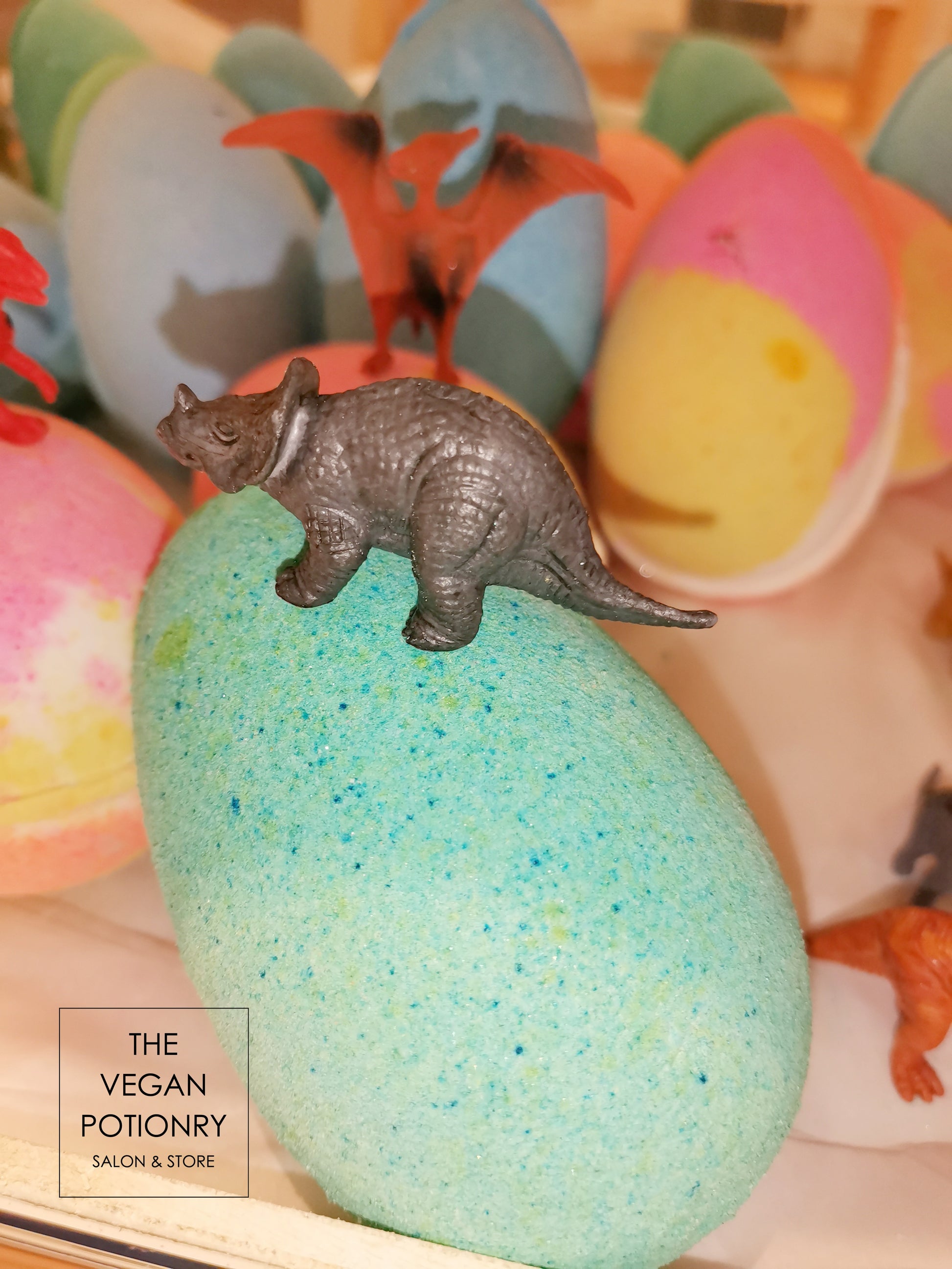 Green Dino egg bath bombs with dinosaur toys inside