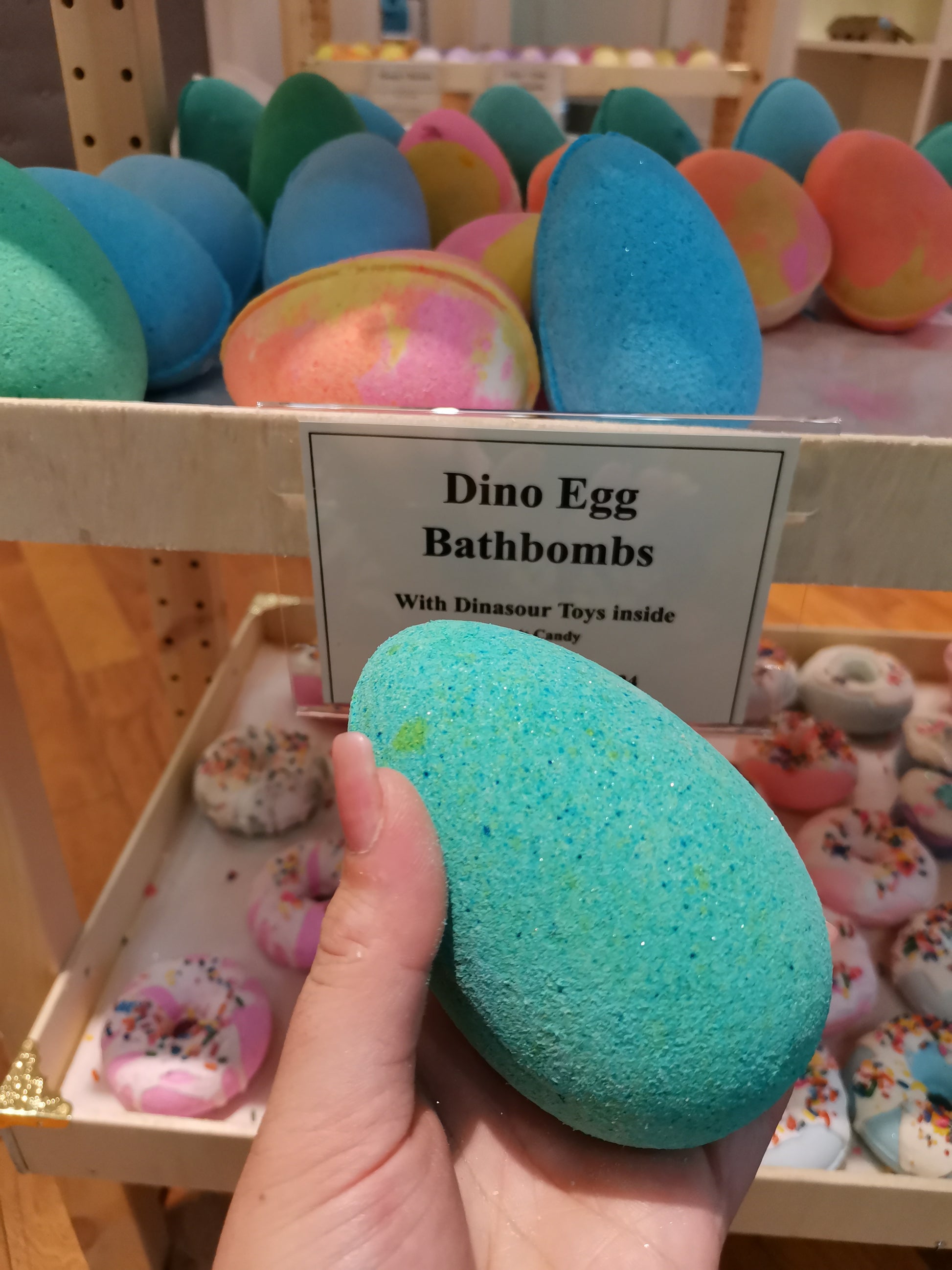 Teal Dino egg bath bombs with dinosaur toys inside